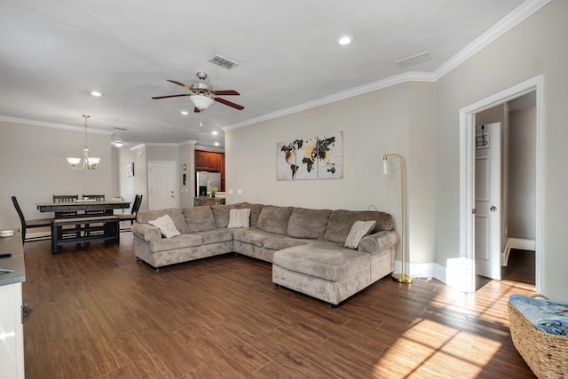 living room featuring ceiling fan with notable chandelier, dark hardwood / wood-style flooring, and ornamental molding