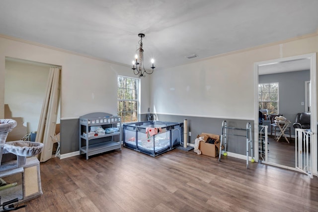 interior space featuring crown molding, hardwood / wood-style floors, and a notable chandelier