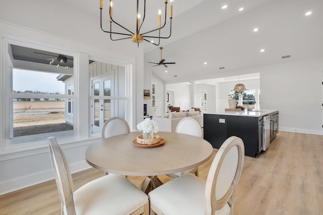 dining room featuring lofted ceiling, sink, light hardwood / wood-style floors, and ceiling fan