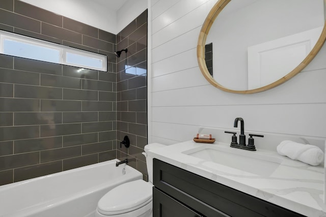 full bathroom featuring tiled shower / bath, vanity, and toilet