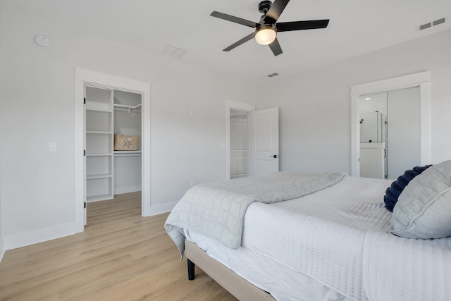 bedroom with ceiling fan, a walk in closet, light hardwood / wood-style floors, and a closet