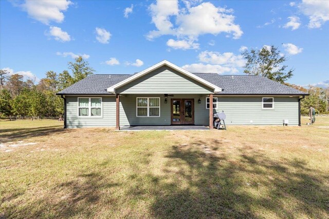 rear view of property with a yard and a patio area