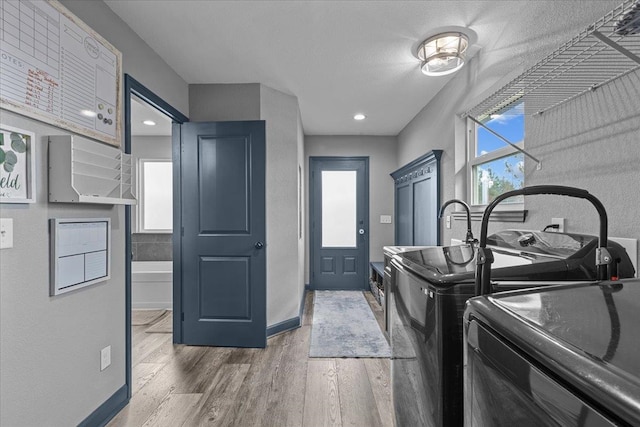 laundry area featuring cabinets, hardwood / wood-style flooring, and separate washer and dryer