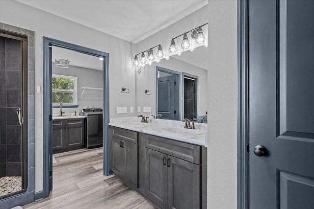 bathroom featuring walk in shower, vanity, hardwood / wood-style flooring, and separate washer and dryer