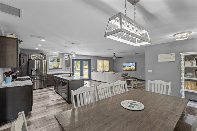 dining room featuring ceiling fan, sink, light hardwood / wood-style flooring, and french doors