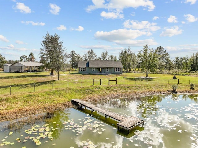 view of dock with a yard and a water view