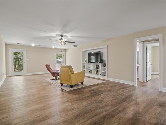 living room with ceiling fan, hardwood / wood-style flooring, and a healthy amount of sunlight