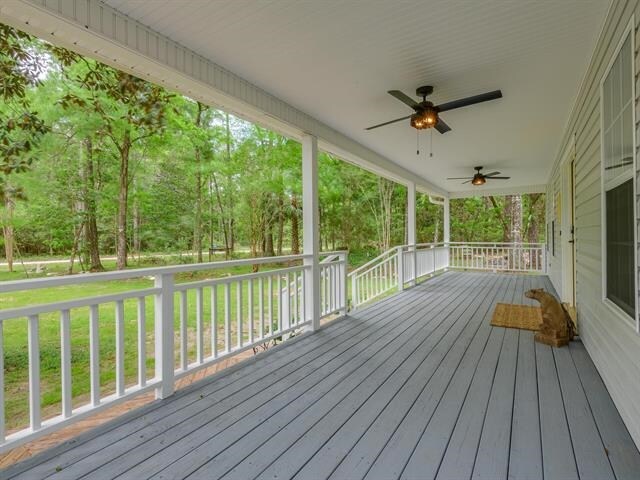 deck with covered porch, ceiling fan, and a lawn