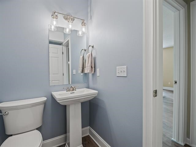 bathroom featuring hardwood / wood-style flooring, toilet, and sink