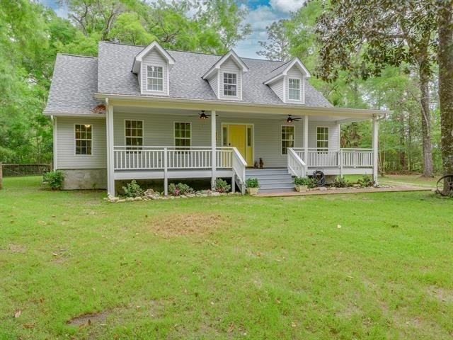 cape cod house featuring a porch, a front yard, and ceiling fan