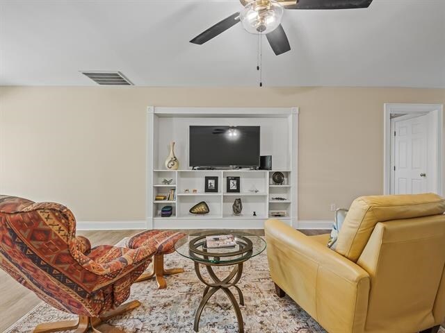 living room featuring hardwood / wood-style flooring and ceiling fan