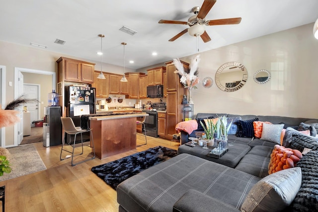 living room featuring ceiling fan and light hardwood / wood-style flooring