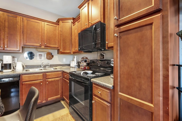 kitchen with black appliances, sink, and light hardwood / wood-style floors