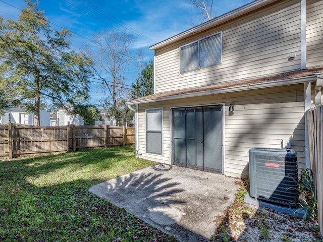 back of house featuring central AC, a patio area, and a lawn