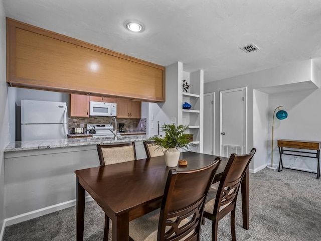 dining area with sink and carpet floors