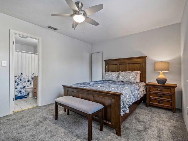 carpeted bedroom with ceiling fan and ensuite bathroom