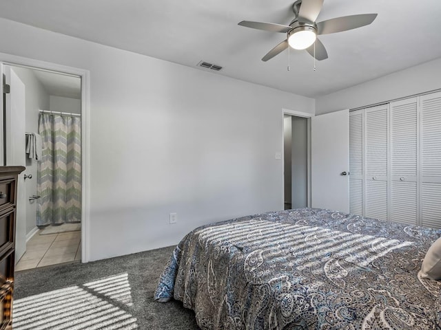 bedroom with ceiling fan, light tile patterned floors, ensuite bath, and a closet