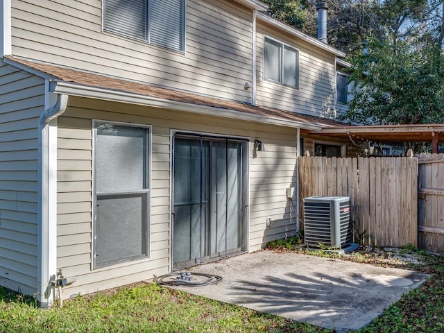 rear view of house with central AC unit and a patio area