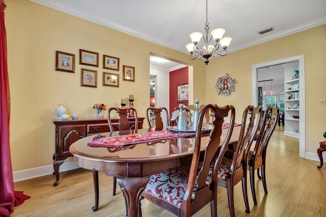 dining space featuring a notable chandelier, light wood-type flooring, and ornamental molding