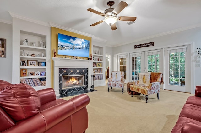 living room with ceiling fan, light colored carpet, built in features, and crown molding