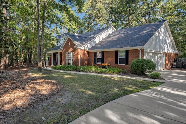 view of front of home featuring a front lawn, central AC unit, and a garage