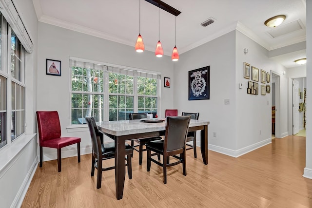 dining area featuring ornamental molding and light hardwood / wood-style flooring