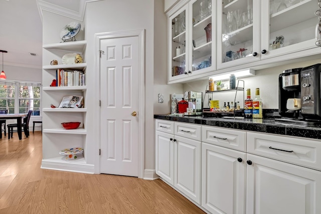 bar featuring white cabinetry, ornamental molding, decorative light fixtures, and light wood-type flooring