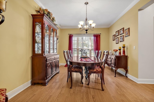 dining room featuring light hardwood / wood-style floors, ornamental molding, and a chandelier