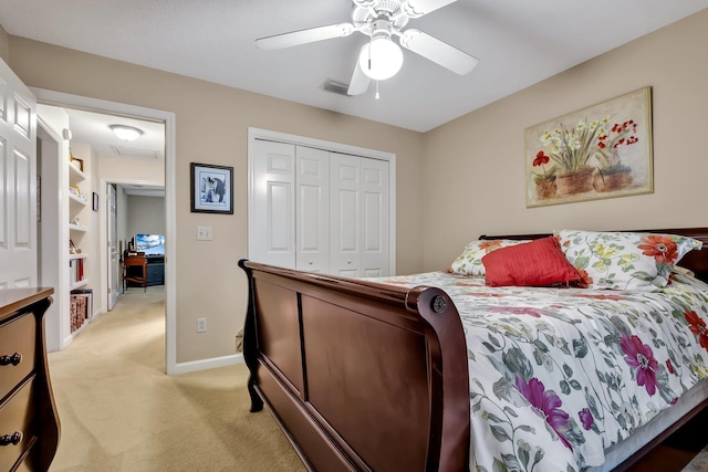 carpeted bedroom with ceiling fan and a closet