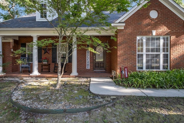 view of exterior entry featuring covered porch