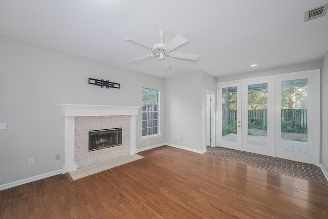 unfurnished living room featuring a fireplace, hardwood / wood-style flooring, and ceiling fan