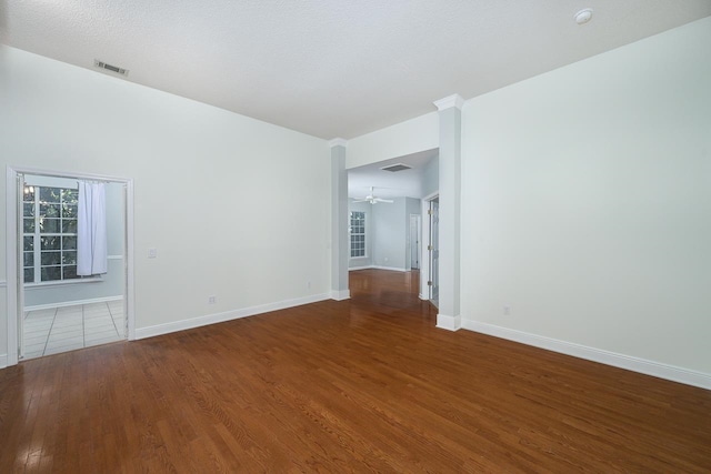 empty room with a textured ceiling, hardwood / wood-style flooring, and ceiling fan