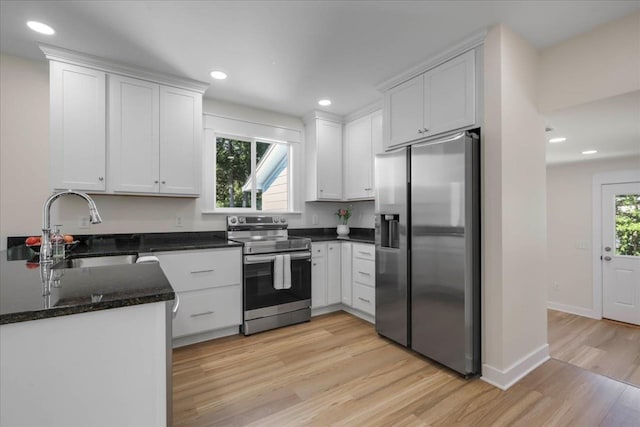 1602 Carruthers St, Tallahassee, FL 32308 - kitchen with stainless steel appliances, a sink, light wood-style flooring, white cabinets, and recessed lighting