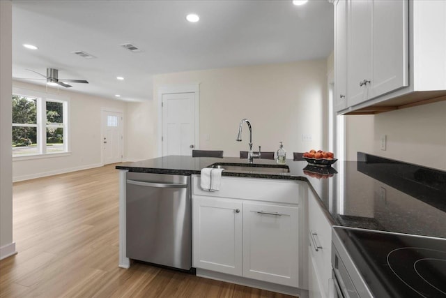 1602 Carruthers St, Tallahassee, FL 32308 - kitchen with stainless steel dishwasher, a sink, a peninsula, light wood finished floors, and dark stone counters