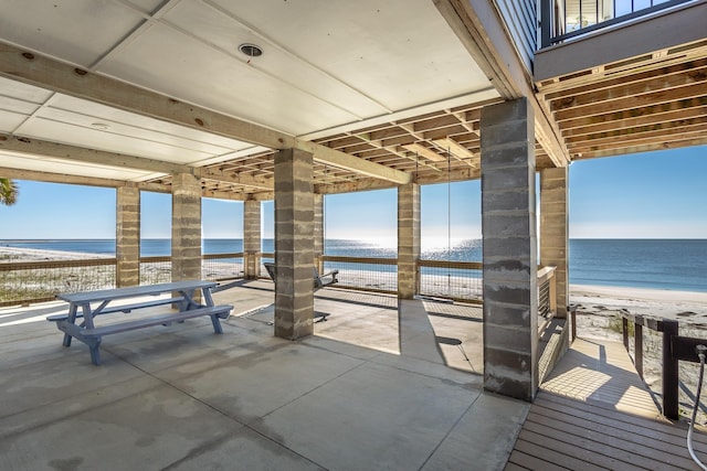 view of patio with a beach view and a water view