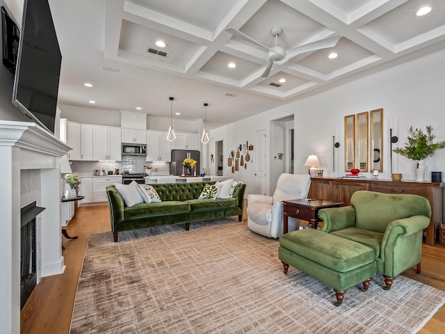 5717 Bascom Ln, Tallahassee, FL 32309 - living room with coffered ceiling, light wood finished floors, a fireplace, recessed lighting, and beamed ceiling
