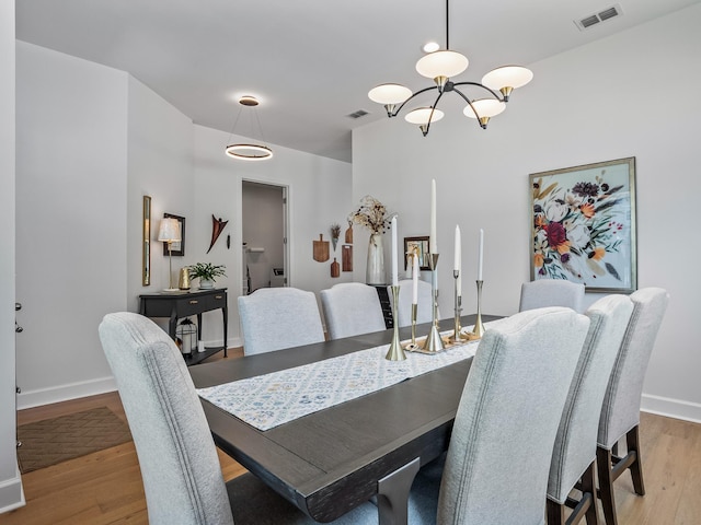 5717 Bascom Ln, Tallahassee, FL 32309 - dining space with light wood-type flooring, a chandelier, and baseboards