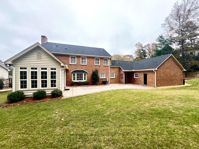 rear view of house with a yard and a patio