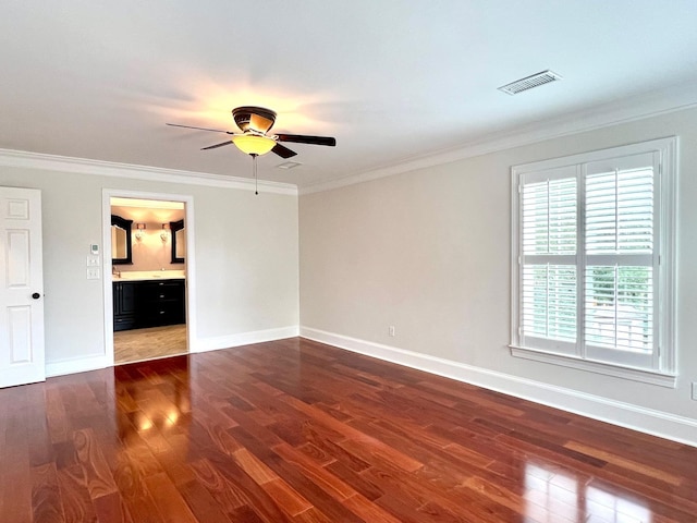 empty room with crown molding and dark wood-type flooring