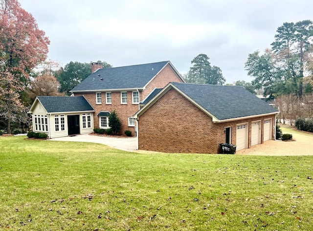 back of property with a yard and a garage