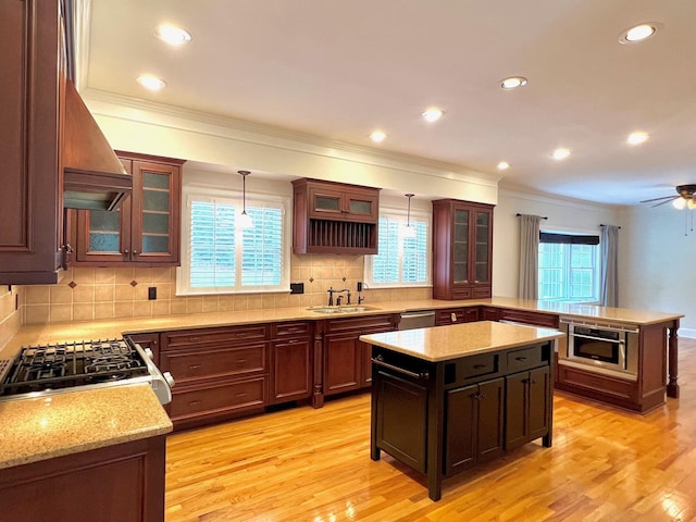 kitchen with light hardwood / wood-style flooring, a kitchen island, and hanging light fixtures