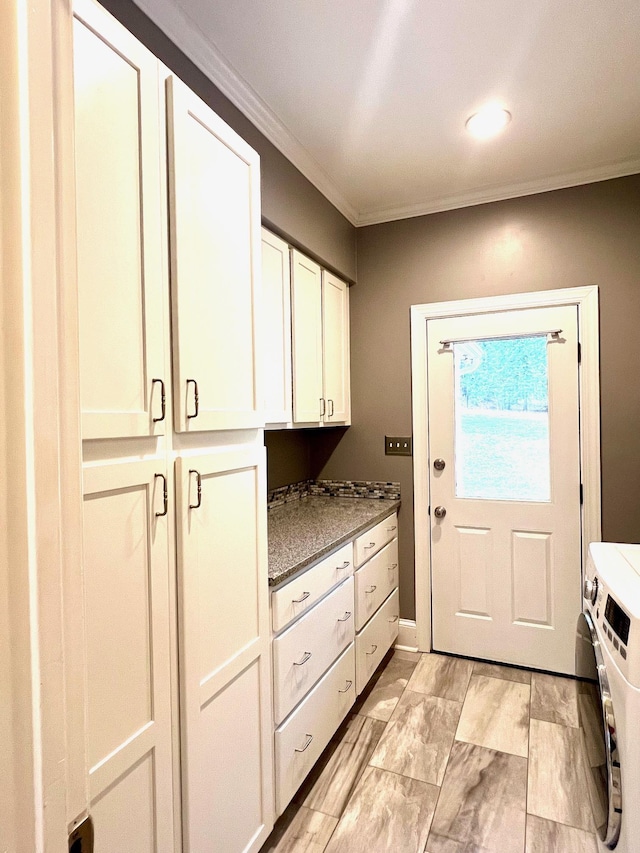 interior space with cabinets, washing machine and dryer, and crown molding