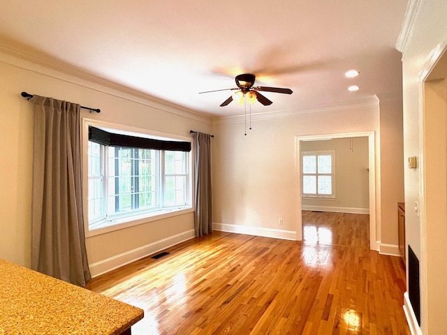 unfurnished room with ceiling fan, wood-type flooring, and ornamental molding