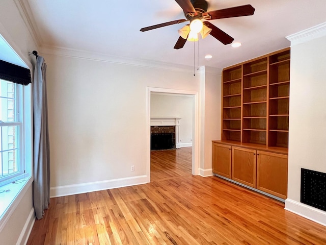 unfurnished living room with light wood-type flooring, ceiling fan, and crown molding