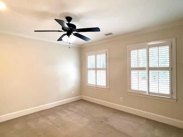 carpeted spare room with crown molding and ceiling fan