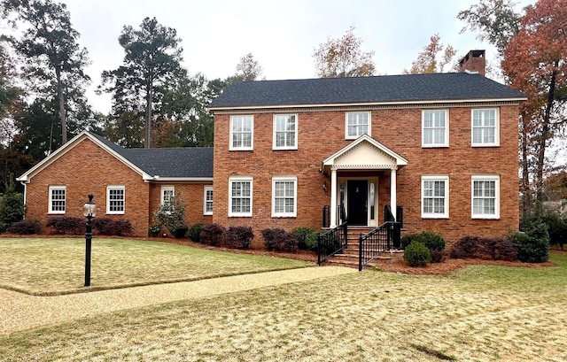 colonial home featuring a front lawn