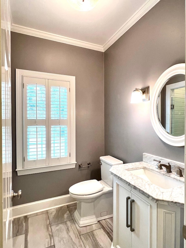 bathroom with vanity, toilet, and crown molding