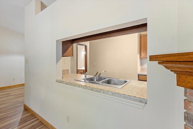 kitchen with sink and light hardwood / wood-style flooring