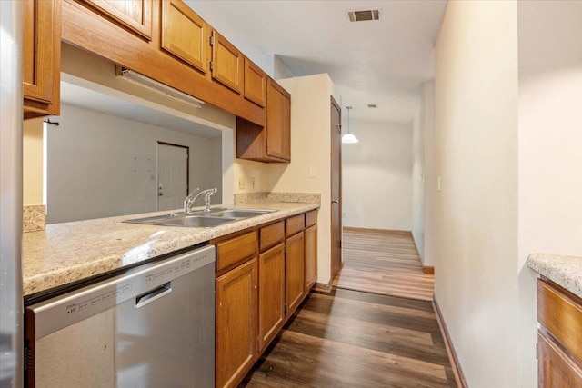 kitchen featuring dishwasher, sink, dark wood-type flooring, and decorative light fixtures