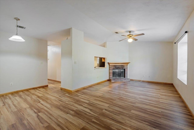 unfurnished living room with a brick fireplace, light hardwood / wood-style flooring, ceiling fan, and lofted ceiling